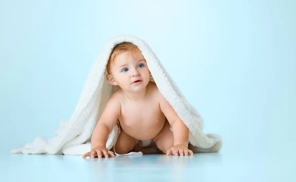 かわいい かわいい赤ちゃん 穏やかにタオルで子供は ライトブルーのスタジオの背景にクロールを開始します 子供の頃の概念 新生児のライフスタイル Adのためのスペースをコピーする — ストック写真