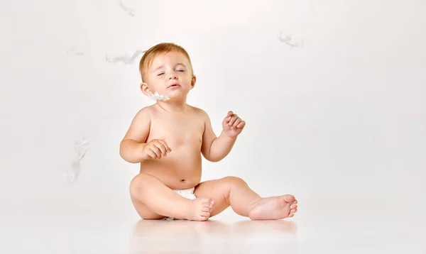 白いスタジオの背景に床に座っているおむつの中の美しい小さな赤ちゃん 穏やかな子供たち 子供の頃の概念 新生児のライフスタイル Adのためのスペースをコピーする — ストック写真