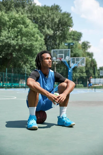 Joven Hombre Con Rastas Atleta Uniforme Azul Sentado Pelota Baloncesto —  Fotos de Stock