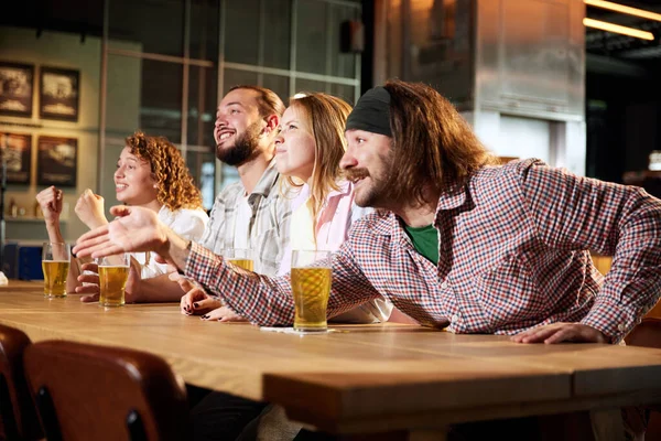 兴奋的体育迷 朋友们在酒吧聚会 喝啤酒 看电视上的足球比赛 大声叫喊 鼓舞球队 体育竞赛的概念 业余爱好 生活方式 人类情感 — 图库照片