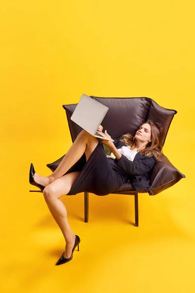 Bizneswoman Siedzi Dziwnej Pozycji Niewygodny Fotel Pracuje Laptopie Jasnożółtym Tle — Zdjęcie stockowe