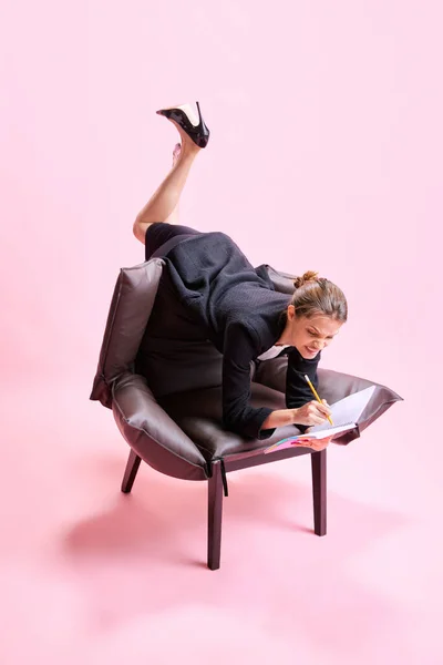愤怒和烦躁 商业女性躺在扶手椅上 姿势怪异 并在粉红的工作室背景下放置笔记 业务概念 日常工作 截止日期 自由应聘人员 办公室 — 图库照片