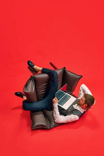 Бизнесмен Служащий Сидящий Кресле Странном Неудобном Положении Работающий Над Ноутбуком — стоковое фото