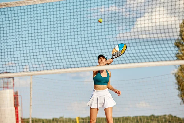 Imagem Dinâmica Jovem Mulher Jogando Tênis Praia Batendo Bola Com — Fotografia de Stock
