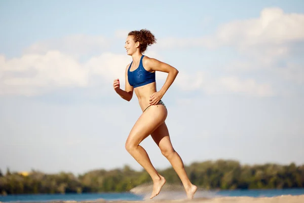 一个体形苗条 健康的年轻女子在温暖的夏日室外海滩上奔跑 体育概念 积极健康的生活方式 业余爱好 — 图库照片