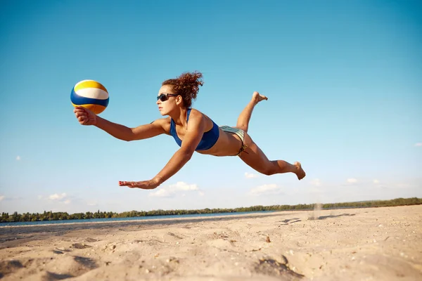 年轻女子的动态形象在运动 打沙滩排球 打球和摔倒在沙滩上 阳光灿烂温暖的一天 体育概念 积极健康的生活方式 业余爱好 — 图库照片