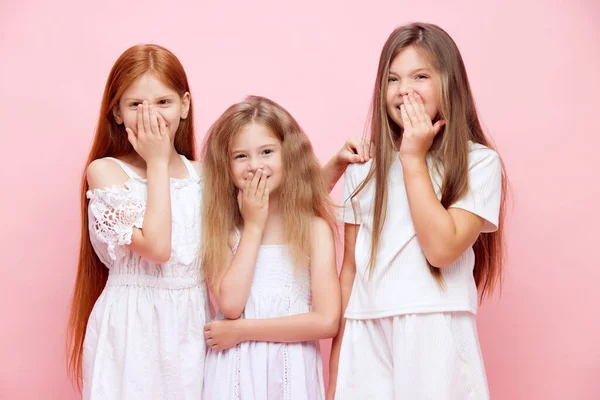 陽気な小さな女の子の肖像画 手で口を覆い 笑顔を隠し ピンクのスタジオの背景に笑った子供たち スキンケア 子供時代 化粧品 ウェルネス 広告のコンセプト — ストック写真