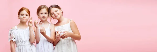 小さな女の子 子供のための自然な化粧品を使用して ピンクのスタジオの背景に対する皮膚の世話をする子供たち スキンケア 子供時代 化粧品 広告のコンセプト — ストック写真