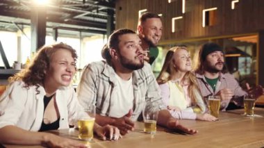 İnsanlar, arkadaşlar barda oturuyor, dikkatle futbol maçı çevirisini izliyor, bira içiyor. Kazanmak ve kaybetmek. Spor yarışması kavramı, hobi, yaşam tarzı, insani duygular, eğlence