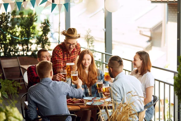 快乐的年轻人 朋友们在温暖的夏日遇见了一家酒吧 喝着美味的啤酒 玩得很开心 传统品味 闲暇时间 享乐等概念 — 图库照片