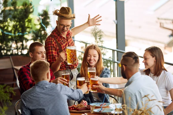 积极的年轻人 朋友们在酒吧见面 兴高采烈地聊天 喝啤酒 有食物放松时间在一起 传统品味 闲暇时间 享乐等概念 — 图库照片