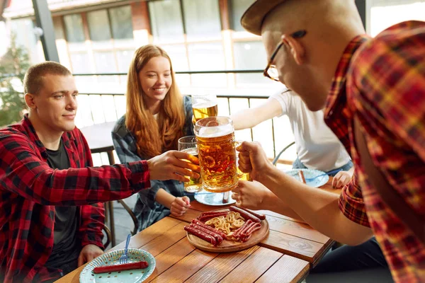 积极的年轻人 朋友们在酒吧见面 兴高采烈地聊天 喝啤酒 有食物放松时间在一起 传统品味 闲暇时间 享乐等概念 — 图库照片