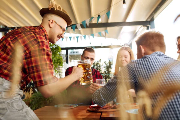 年轻快乐的人们 朋友们在阳光灿烂的日子相聚在酒吧里 喝着淡淡的啤酒 庆祝节日 玩得很开心 传统品味 闲暇时间 享乐等概念 — 图库照片
