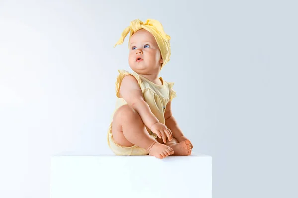かわいい 美しい赤ん坊の少女 魅力的な黄色い服の幼児は静かに座って灰色のスタジオの背景の上にポーズします 子供時代 ライフスタイル ケアコンセプト Adのためのスペースをコピーする — ストック写真