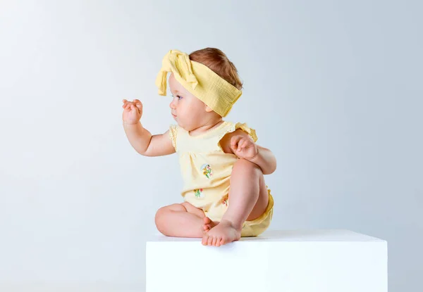 かわいい 美しい赤ん坊の少女 魅力的な黄色い服の幼児は静かに座って灰色のスタジオの背景の上にポーズします 子供時代 ライフスタイル ケアコンセプト Adのためのスペースをコピーする — ストック写真