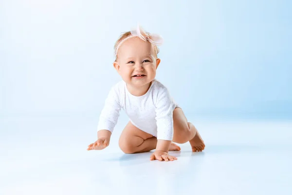 かわいい 素敵な 面白い赤ん坊の女の子 幼い子供は青いスタジオの背景に対して床に微笑み クロールします 子供時代 新生児のライフスタイル ケアの概念 Adのためのスペースをコピーする — ストック写真