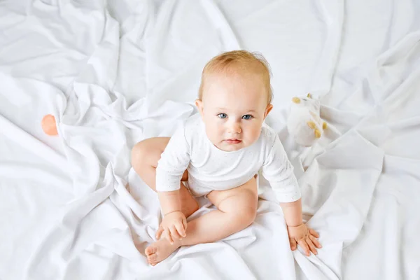 ベッドの上に座って 注意深く上を見下ろす愛らしい小さな女の子 幼児のトップビューの肖像画 子供時代 新生児のライフスタイル ケアの概念 Adのためのスペースをコピーする — ストック写真