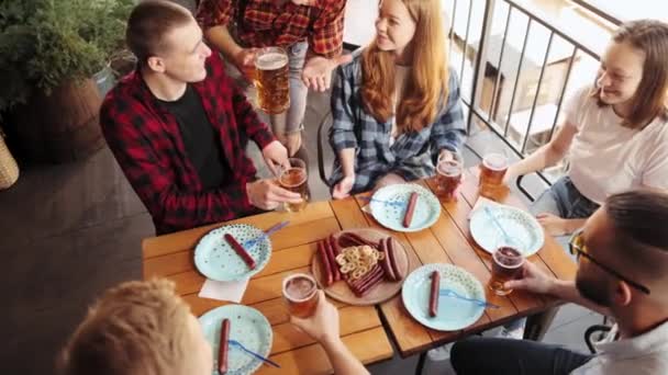 陽気な若者のトップビュー カフェ パブで会う友人 一緒に時間を過ごし ソーセージやスナックでビールを飲む コンセプト Pktoberfest 伝統的な味 レジャー時間 — ストック動画