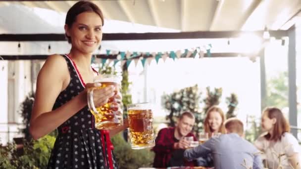 美丽的 微笑的 年轻的女人 侍应生提供大杯子与更多的啤酒给一群年轻人 朋友在酒吧 Oktoberfest Traditional Taste Friendship Leisure — 图库视频影像