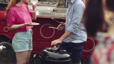 Arkadaşlarla dışarıda parti, piknik, neşeyle konuşmak, kokteyl içmek ve barbekü yapmak. Keyif. Parti, arkadaşlık, yaz, boş zaman, açık hava aktivitesi, eğlence ve neşe kavramı