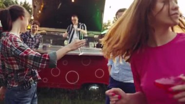 Bir grup genç arkadaş dışarıda barbekü partisinde iyi vakit geçiriyorlar. Minibüste kokteyl yapan yakışıklı adam. Parti, arkadaşlık, yaz, boş zaman, açık hava aktivitesi, eğlence ve neşe kavramı