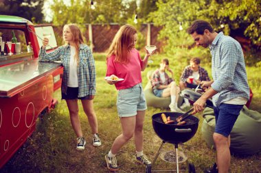 Bir grup genç, arkadaşlar dışarıda vakit geçiriyorlar, barbekü partisi yapıyorlar, yemek pişiriyorlar, kokteyl içiyorlar, konuşuyorlar. Kırsal kesimde toplantı. Arkadaşlık kavramı, boş zaman, hafta sonları, yaz, parti