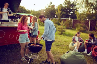 Bir grup genç, arkadaşlar dışarıda vakit geçiriyorlar, barbekü partisi yapıyorlar, yemek pişiriyorlar, kokteyl içiyorlar, konuşuyorlar. Kırsal kesimde toplantı. Arkadaşlık kavramı, boş zaman, hafta sonları, yaz, parti