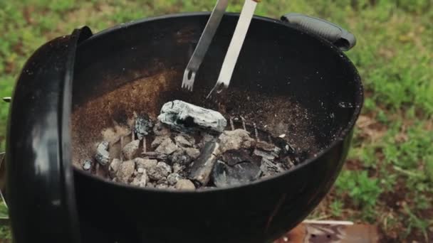 家でバーベキューをする男 屋外で 熱い炭をグリルに入れる 肉を調理する前の準備 夏のピクニック 食べ物 パーティー 料理のコンセプト — ストック動画
