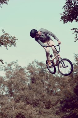 BMX bisikleti süren genç bir adam. Parkta. Özel yollar da ekstrem sürüş için. Güç ve dayanıklılık. Aktif yaşam tarzı, spor, aşırı, dinamik, hobi, fitness kavramı