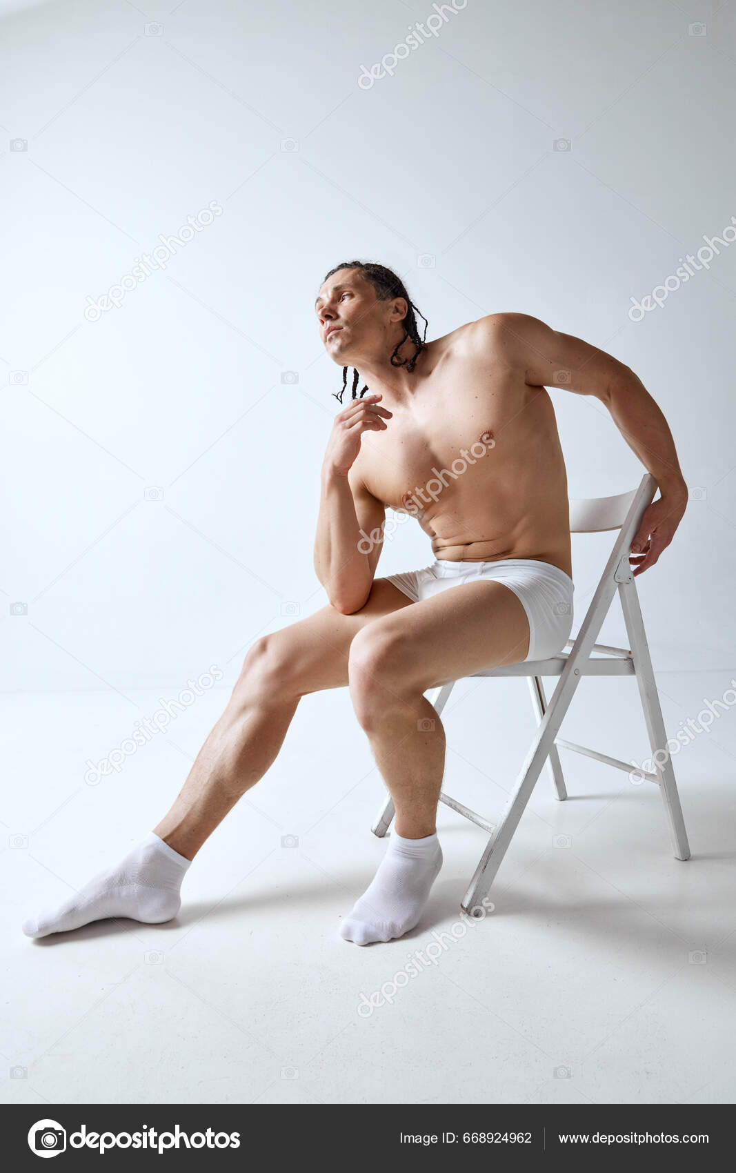 Senior male sitting on a recliner in his undershirt in boxers