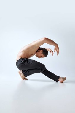 Yakışıklı, atletik, M, usuclar, gri stüdyo arka planına karşı duran güvenilir vücut. Hip hop dansçısı. Erkeklerin güzellik anlayışı, vücut bakımı, moda, sağlık, sağlıklı yaşam tarzı, reklam