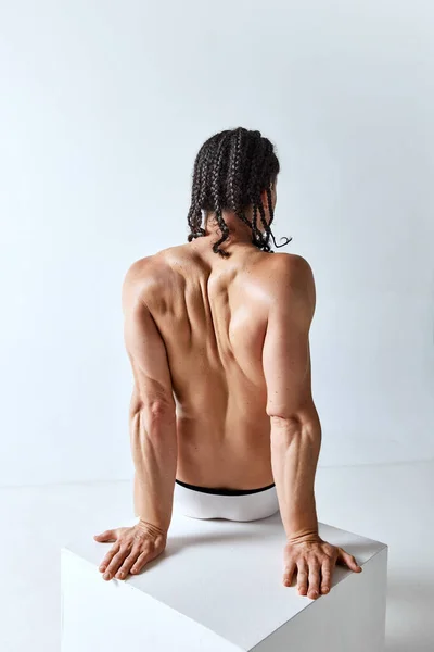 肌肉发达 没有衬衫的男人坐着 在灰色的工作室背景下摆出内裤的姿势 男性美的概念 身体护理 健康的生活方式 — 图库照片