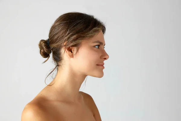 Junge Frau Mit Haarschopf Nackten Schultern Vor Grauem Studiohintergrund Porträt — Stockfoto