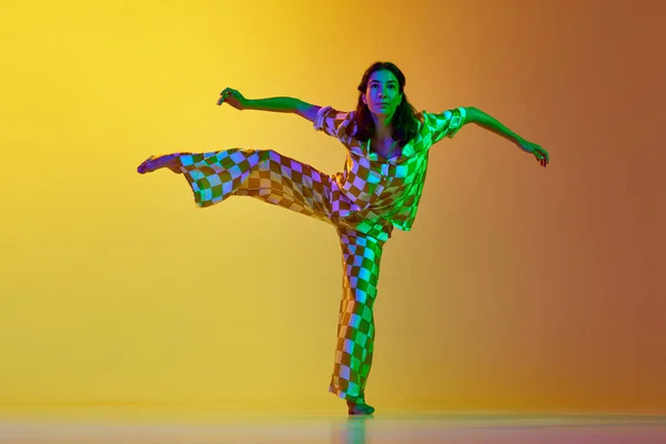 有才华的女子在霓虹灯下 在渐变的黄色橙色背景下跳自由式舞 现代舞风格 生活方式 广告的概念 — 图库照片