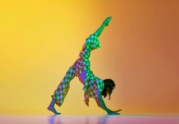 线的姿势 年轻的有才华的女人 专业的舞蹈家在运动 在渐变的橙色背景下在霓虹灯下跳舞 现代舞风格 生活方式 广告的概念 — 图库照片