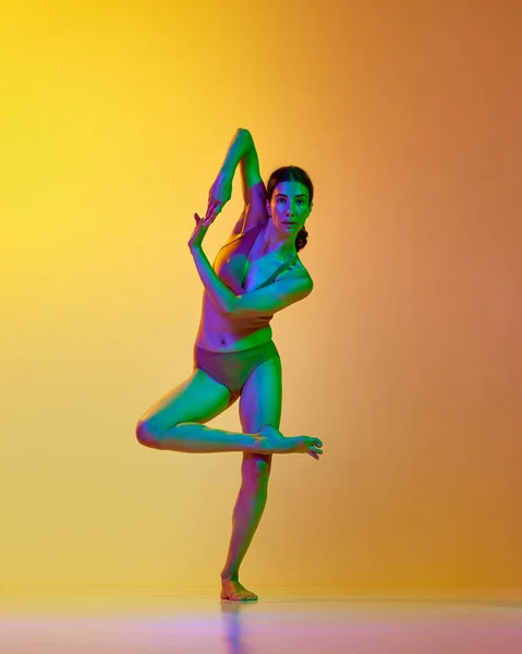 全长的年轻女子形象 专业舞者在运动 内裤跳舞与渐变黄色橙色背景的霓虹灯 现代舞风格 生活方式 广告的概念 — 图库照片