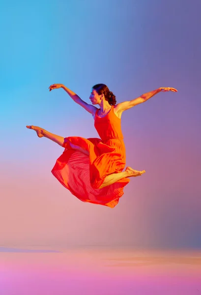 经典和现代 优雅的年轻女子在霓虹灯下穿着渐变的彩色背景的衣服跳舞 现代舞风格 生活方式 广告的概念 — 图库照片