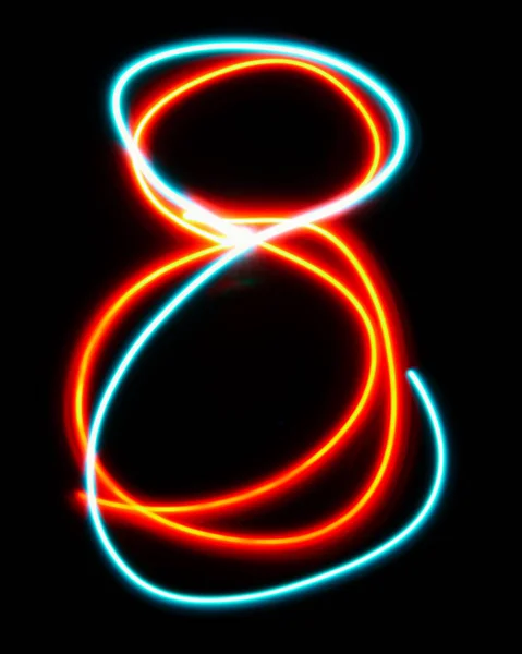 ネオンサインから作られたアルファベットの8つ 青い赤い光のイメージ 黒い背景に対して着色された妖精のライトが付いている長い露出 デザインコンセプト — ストック写真