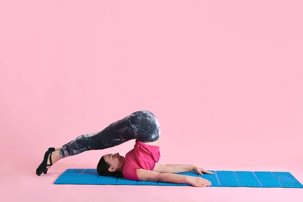 柔軟なボディ 成熟した女性はフィットネスマットでトレーニングし ピンクのスタジオの背景に対して体を伸ばします スポーツ 健康的なライフスタイル フィットネス ボディケア ウェルネス 広告のコンセプト — ストック写真
