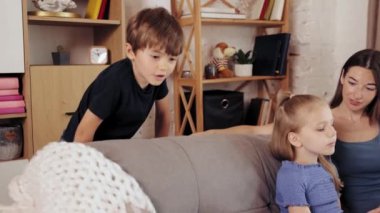 Güzel, genç bir anne çocuklarıyla, oğluyla ve kızıyla evde çok güzel vakit geçiriyor. Eğleniyor, rahatlıyor. İç mekan. Aile kavramı, çocukluk, mutluluk, sevgi ve ilgi