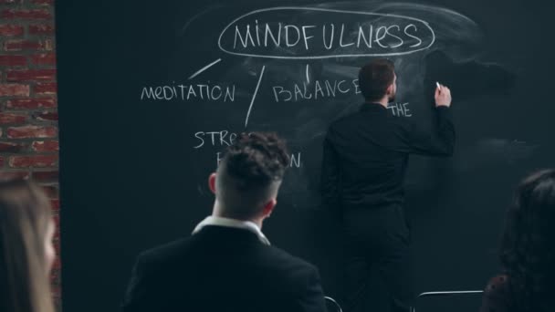 年轻人在黑板尖上写字 树立了思想的成分 与工人 同事会面 心理学 业务概念 集思广益 — 图库视频影像