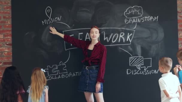 Gündelik Giysiler Içinde Genç Bir Kadın Çocuklara Birlikte Çalışmayı Öğretiyor — Stok video