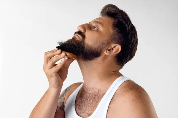 成熟したハンサムな男は 白いスタジオの背景に対して特別なブラシでひげの後に世話します メンズビューティー スキンケア 化粧品 ウェルネスのコンセプト Adのためのスペースをコピーする — ストック写真
