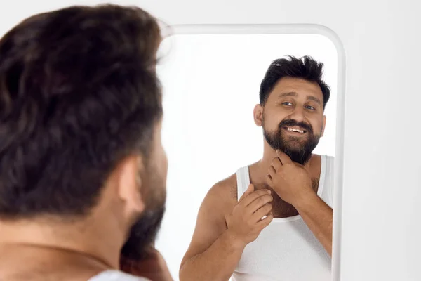 ハンサム 魅力的な髭の男は 鏡を見て笑顔 シャワーの後に顔の世話をする 朝のルーチン メンズビューティー スキンケア ウェルネスのコンセプト — ストック写真