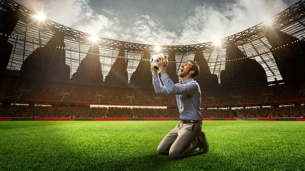 フットボール競技場でひざまずき ボールを抱き お金の勝利を祝う男 成功した賭け 3Dレンダリング スポーツ ファン 賭け金 ギャンブル ブックメーカーのコンセプト — ストック写真