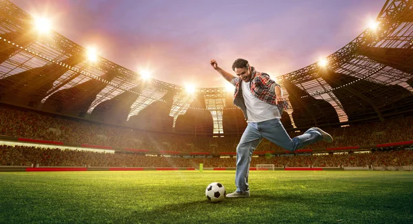 Emotional man hitting football ball on open air arena with flashlights. Netting and match. 3d render. Concept of sport, fan, betting and finances, gambling, bookmaker