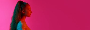 Profil görüntüsü, sakin, duygusuz bir yüzle neon ışıkta pembe stüdyonun arka planına bakan genç bir kız. İnsan duyguları, güzellik, yaşam tarzı, gençlik kavramı. Pankart. İlan için alanı kopyala