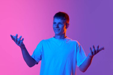 Beyaz tişörtlü genç adam, neon ışıkta, mor arka plandaki değişime karşı sorgulayan yüzüyle ellerini açıyor. İnsan duyguları kavramı, gençlik, yaşam tarzı, moda, yüz ifadeleri, reklam
