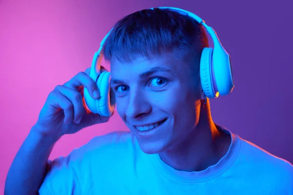 Молодий Позитивний Хлопчик Посміхається Слухаючи Музику Навушниках Проти Градієнтного Рожево — стокове фото