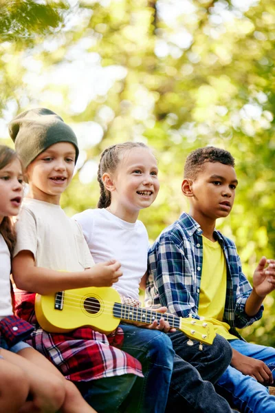 Crianças Felizes Sentadas Floresta Dia Ensolarado Tocando Guitarra Divertindo Caminhadas — Fotografia de Stock